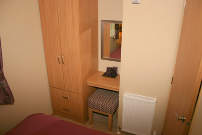 There is a small dressing table and stool plus a TV point in the main bedroom