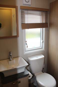 ABI Roxbury holiday home - The shower room has a ceramic washbasin and a two door vanity cupboard plus an extractor fan in the wall.