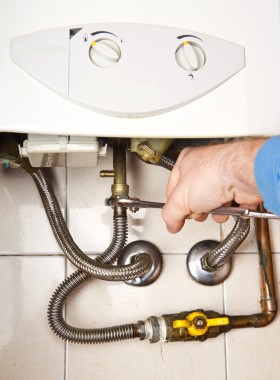 Plumber at work. Servicing gas boiler